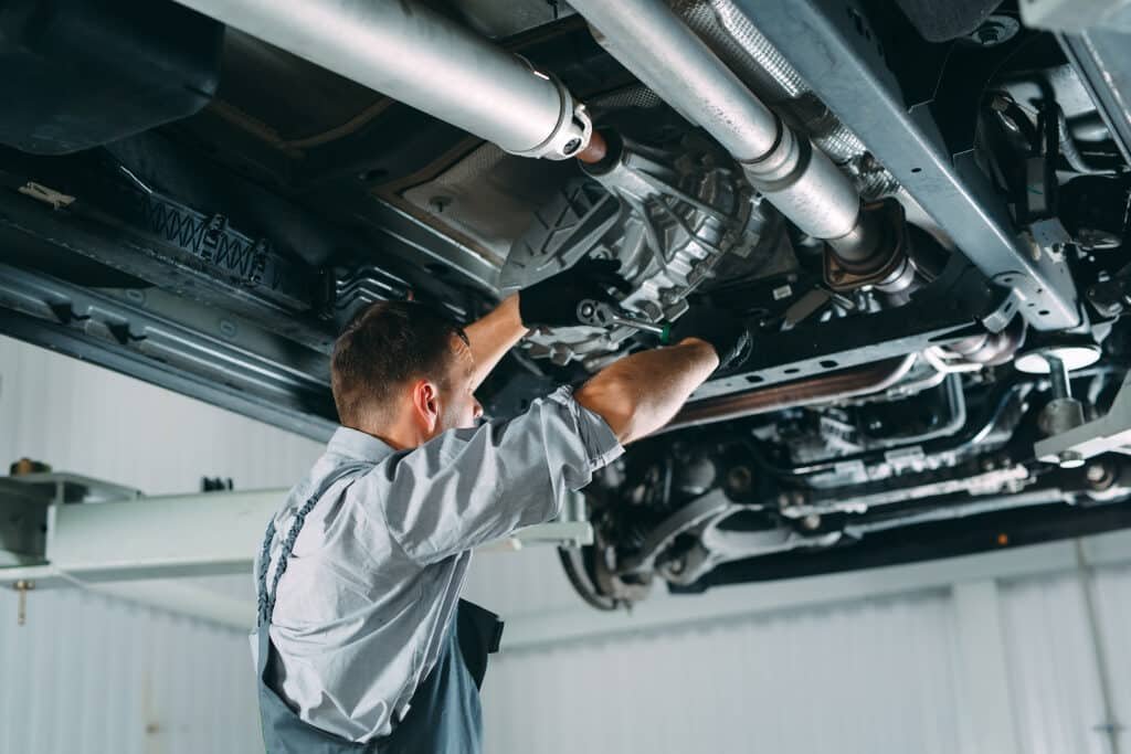 Portrait of a mechanic repairing a lifted car